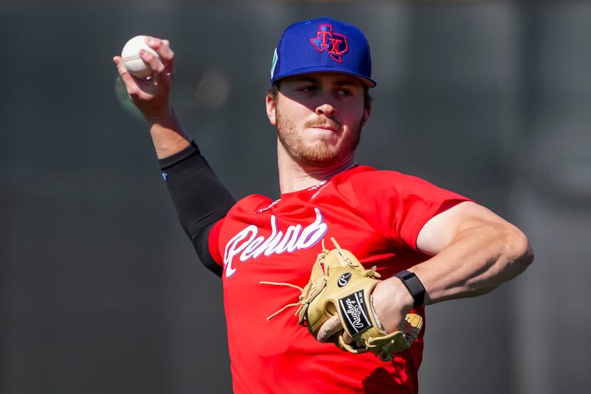 Pitcher Dane Acker throws during a Texas Rangers minor league spring camp workout at the...