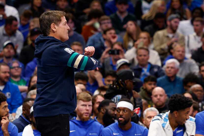 Dallas Mavericks owner Mark Cuban signals for a traveling during a timeout in the second...