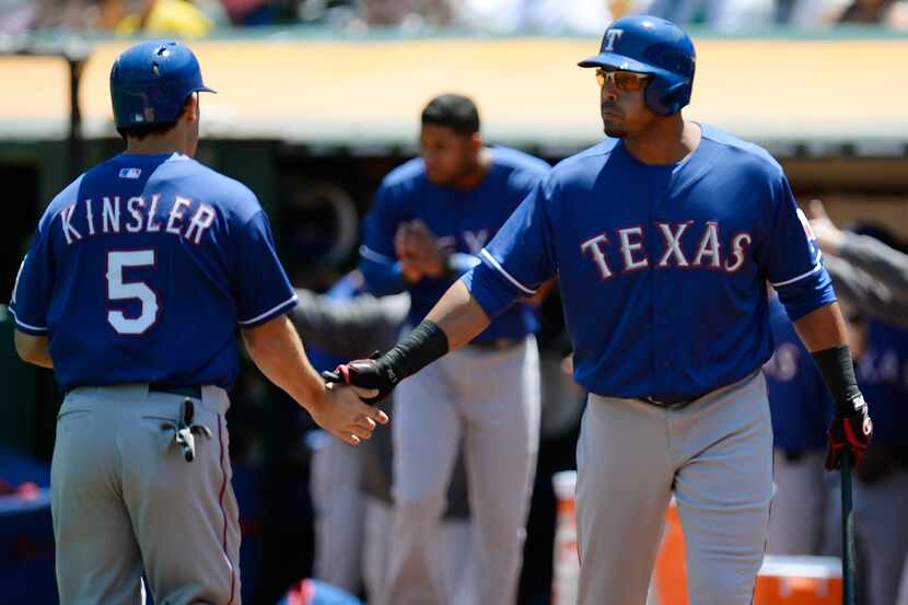OAKLAND, CA - AUGUST 04:  Ian Kensler #5 of the Texas Rangers is congratulated by Nelson...