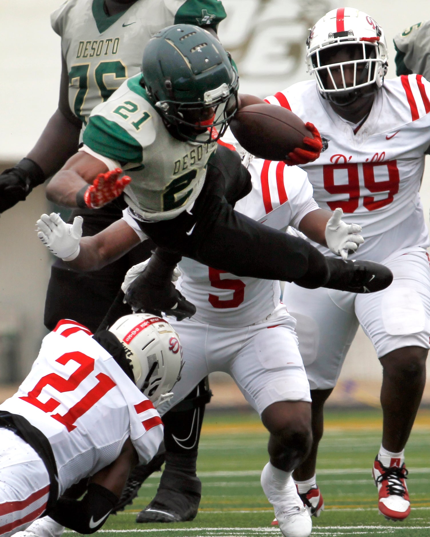 DeSoto running back Jaylin Jones (21) is tripped up by Duncanville defensive back Tyren...