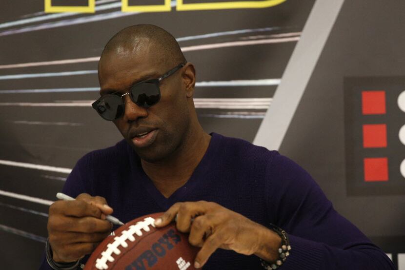 FILE - Former Dallas Cowboy Terrell Owens signs a football at The Ticket Sportradio's...