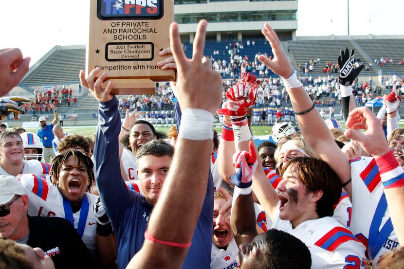 Parish Episcopal head football coach Daniel Novakov hoists the state title trophy to the...