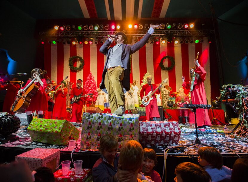 Tim DeLaughter, center, lead singer of The Polyphonic Spree, performs with other members...