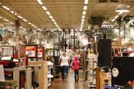 Shoppers pass in front of 'Sale' signs displayed at a Bass Pro Outdoor World LLC store on...