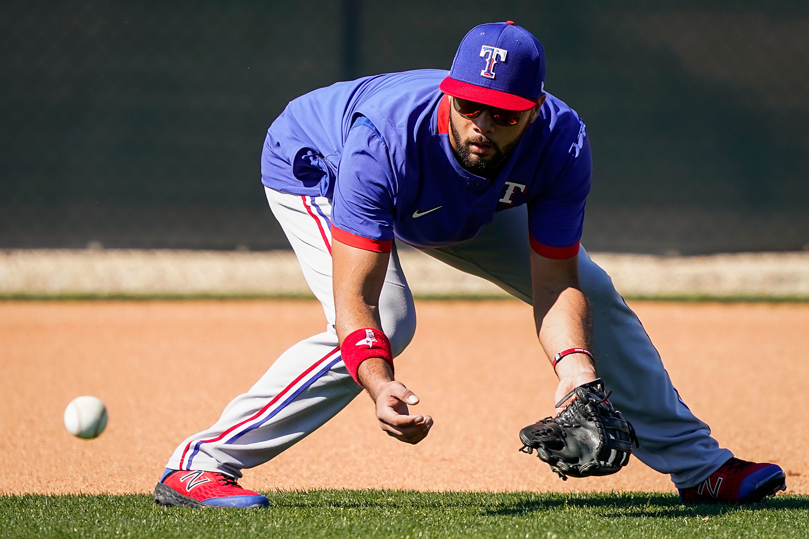 Texas Rangers infielder Isiah Kiner-Falefa takes grounders at shortstop during an informal...