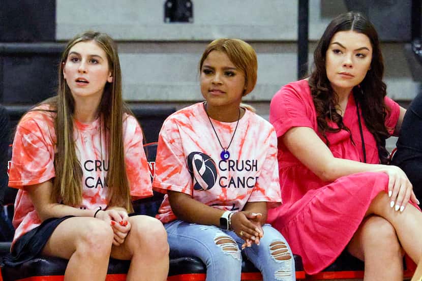 Team managers Nayeli Soto (center) and Emily Mabry (left) sit alongside assistant coach...