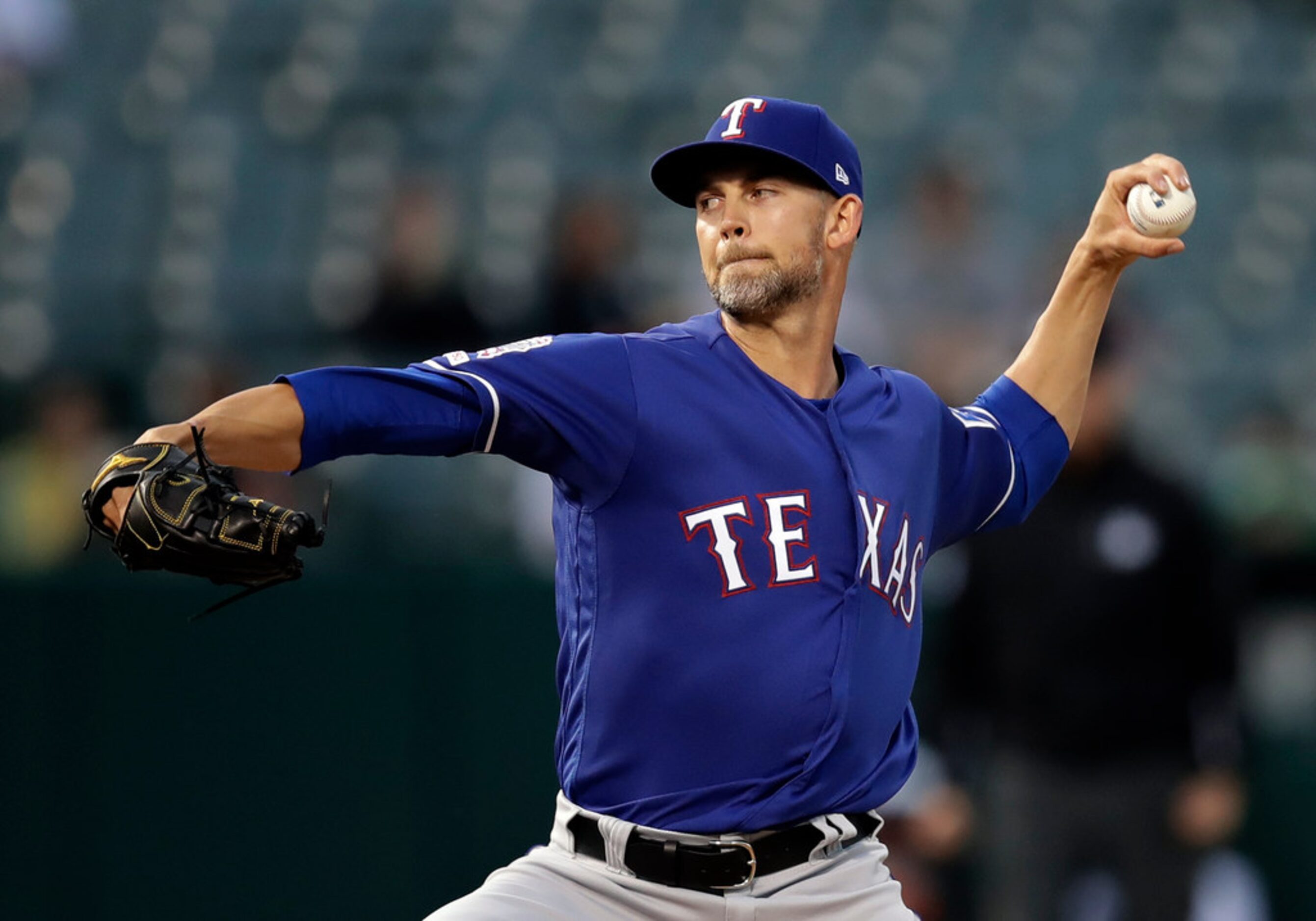 Texas Rangers pitcher Mike Minor works against the Oakland Athletics in the first inning of...