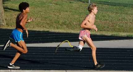 Southlake Carroll High School cross-country runner Chris Tracht, 15, right, works out with...