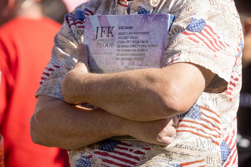 An attendee holds a book called “JFK Absolute Proof” as the JFK Historical Group held a...