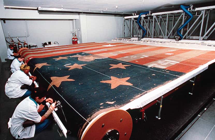 A photo released by Smithsonian Institution shows curators restoring the Star-Spangled...