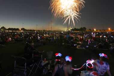 Community members watch a fireworks display during an early Fourth of July celebration at...
