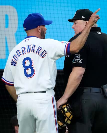 Texas Rangers manager Chris Woodward argues with umpire Bill Miller after a video replay of...