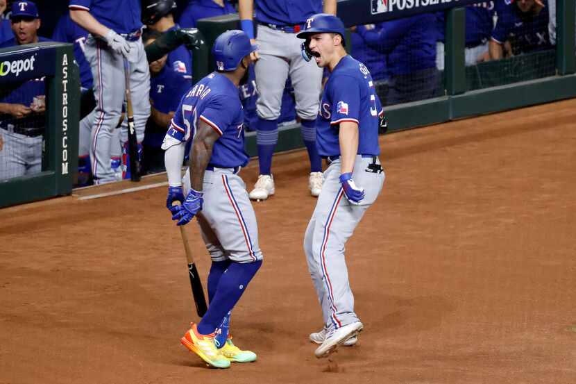 Texas Rangers Corey Seager (right) is congratulated on his solo home run by teammate Adolis...