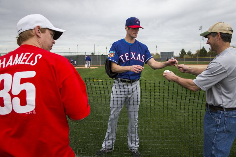 Texas Rangers pitcher Cole Hamels signs autographs for fans during the first full spring...