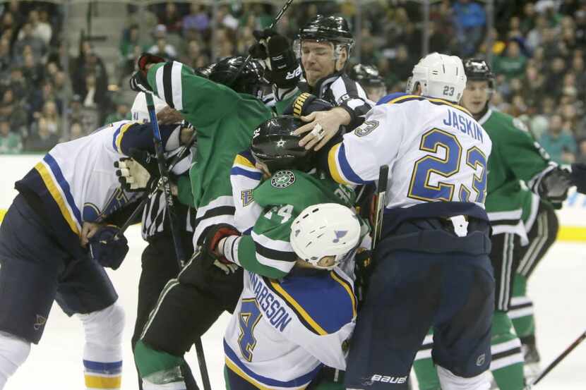 St. Louis Blues and Dallas Stars players tangle during the first period of an NHL hockey...