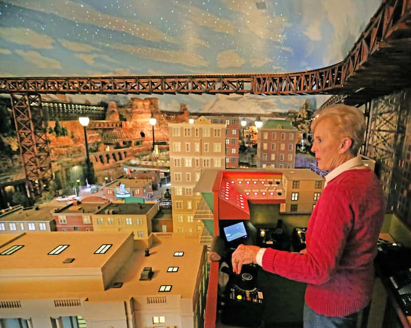 Jane Sanders runs the controls of the model train display built by her husband Stephen in...