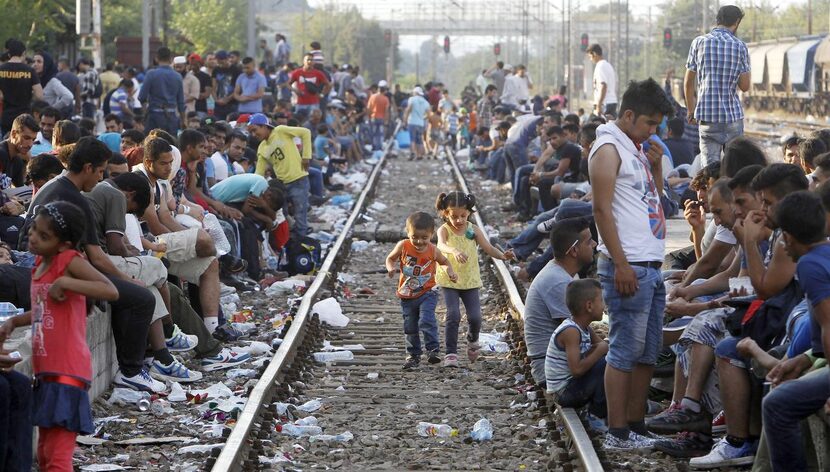 Migrant children  play on a railroad track in southern Macedonia as their parents wait for a...