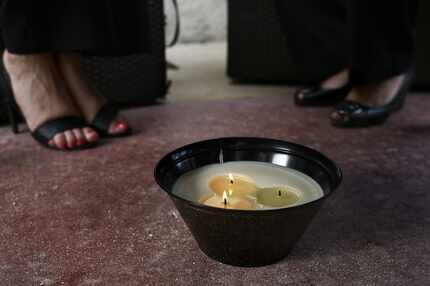 A citronella candle burns under a table at Meat Market, a steakhouse in Miami Beach, Fla.,...