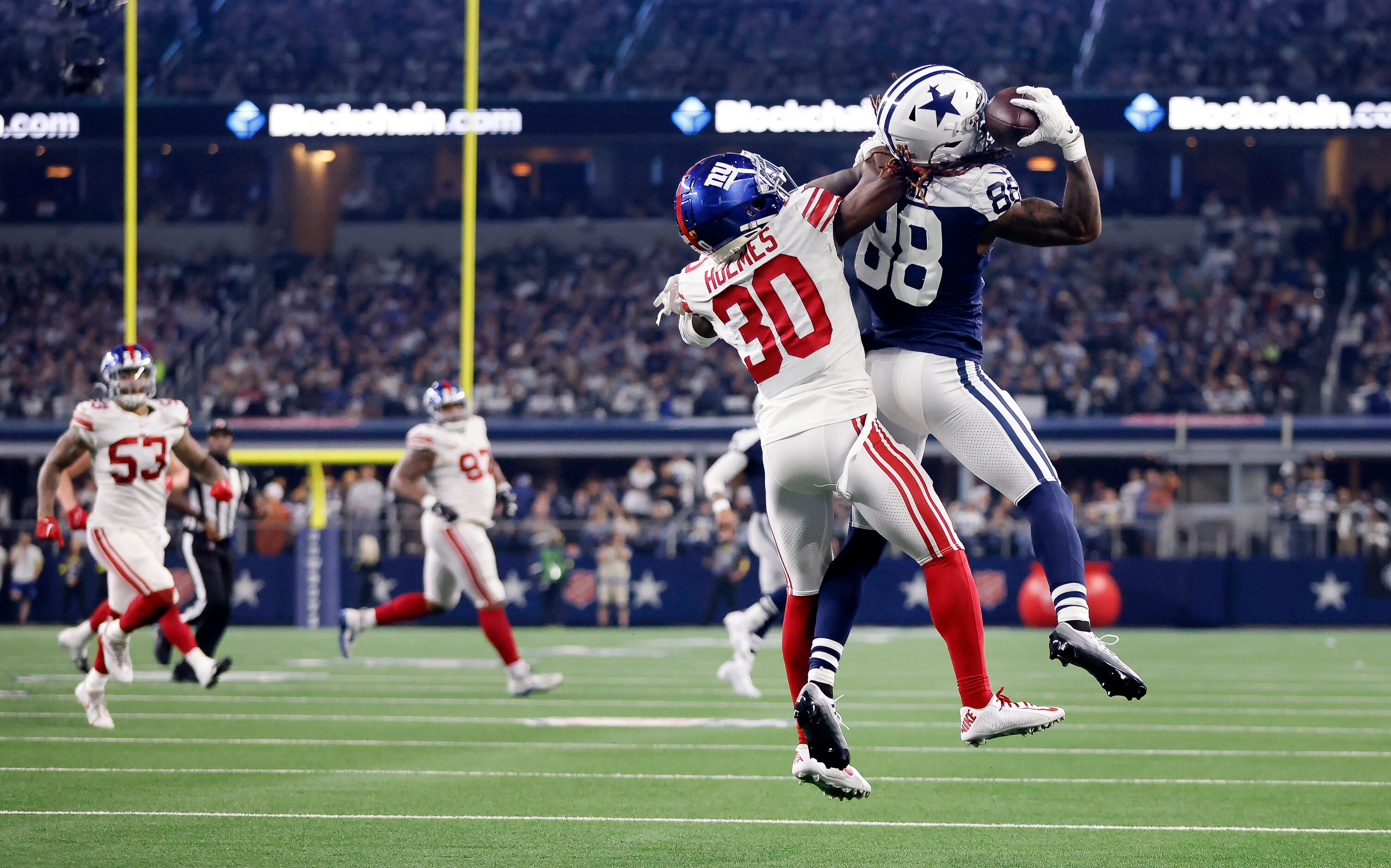 Dallas Cowboys wide receiver CeeDee Lamb (88) presses the ball to his helmet as he makes a...