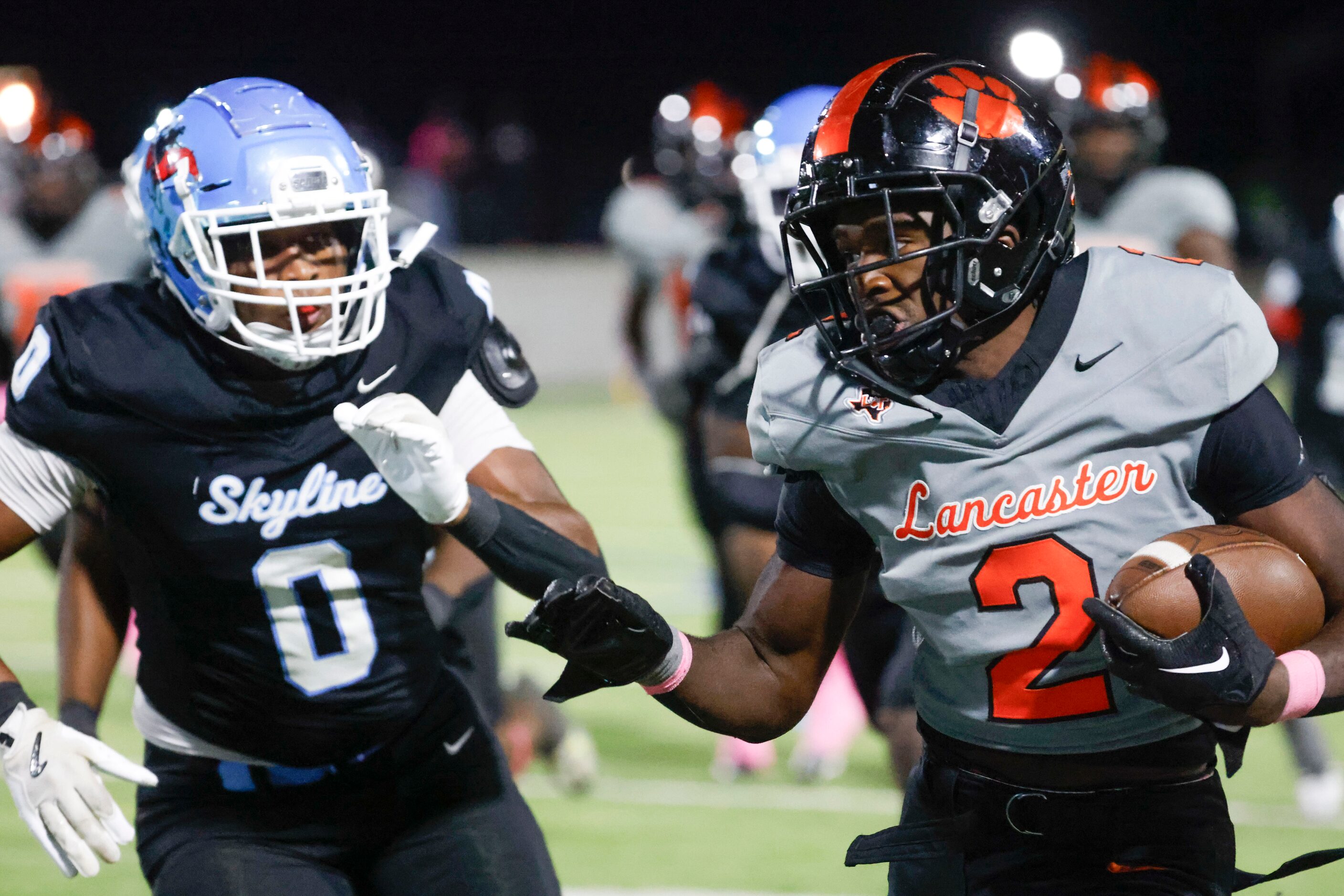 Lancaster High’s Izayah Lee (right) runs for a yardage past Skyline High’s Elijah Barnes...