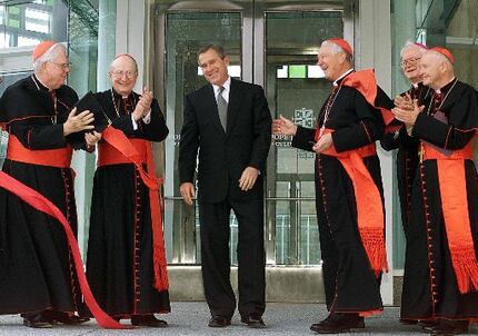  President George W. Bush smiles as he is applauded by Cardinals Bernard Law of Boston (from...