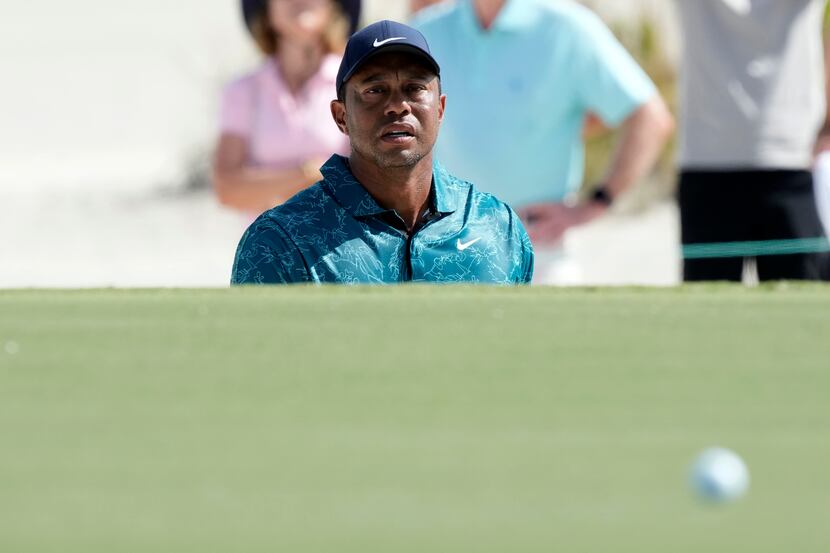 Tiger Woods watches his shot from a green side bunker during the second round of the Hero...