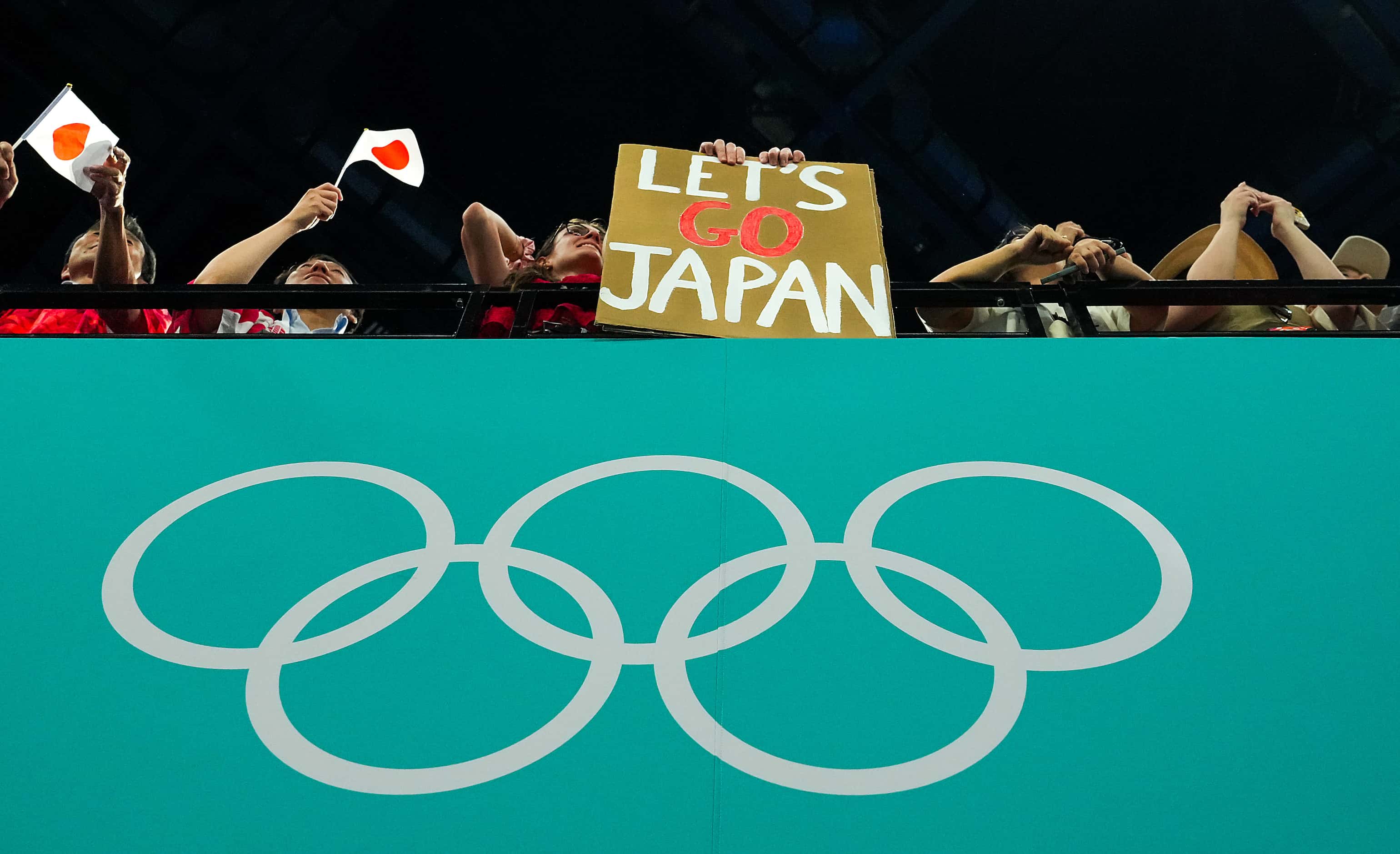 Supporters cheer for gold medalist Japan during the men’s gymnastics team final at the 2024...