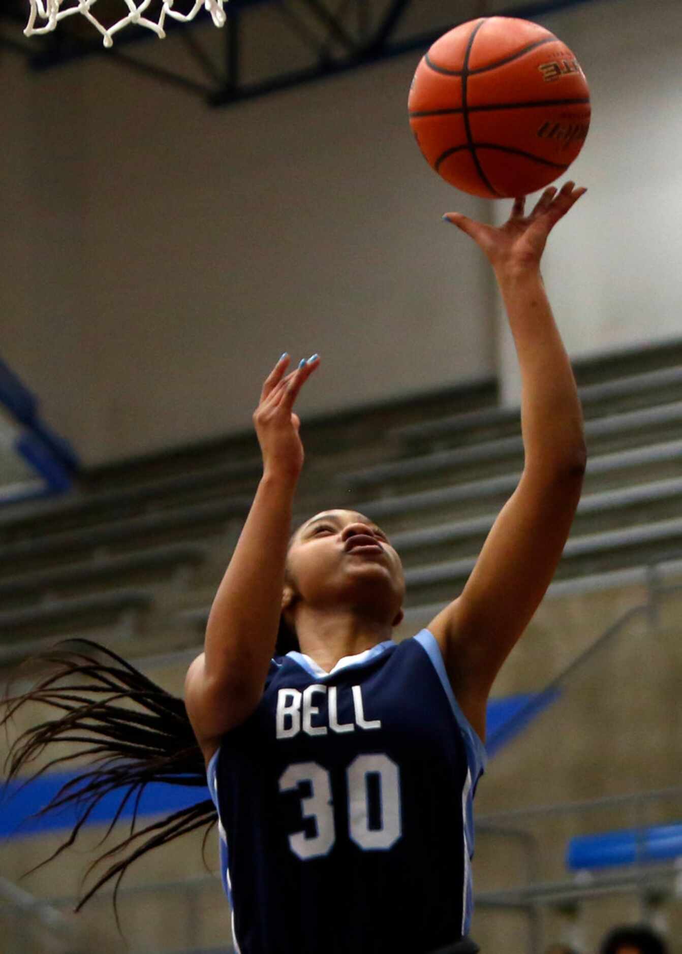 Hurst L. D. Bell's Hallie Rhodes (30) finishes a fast break with a layup during first half...