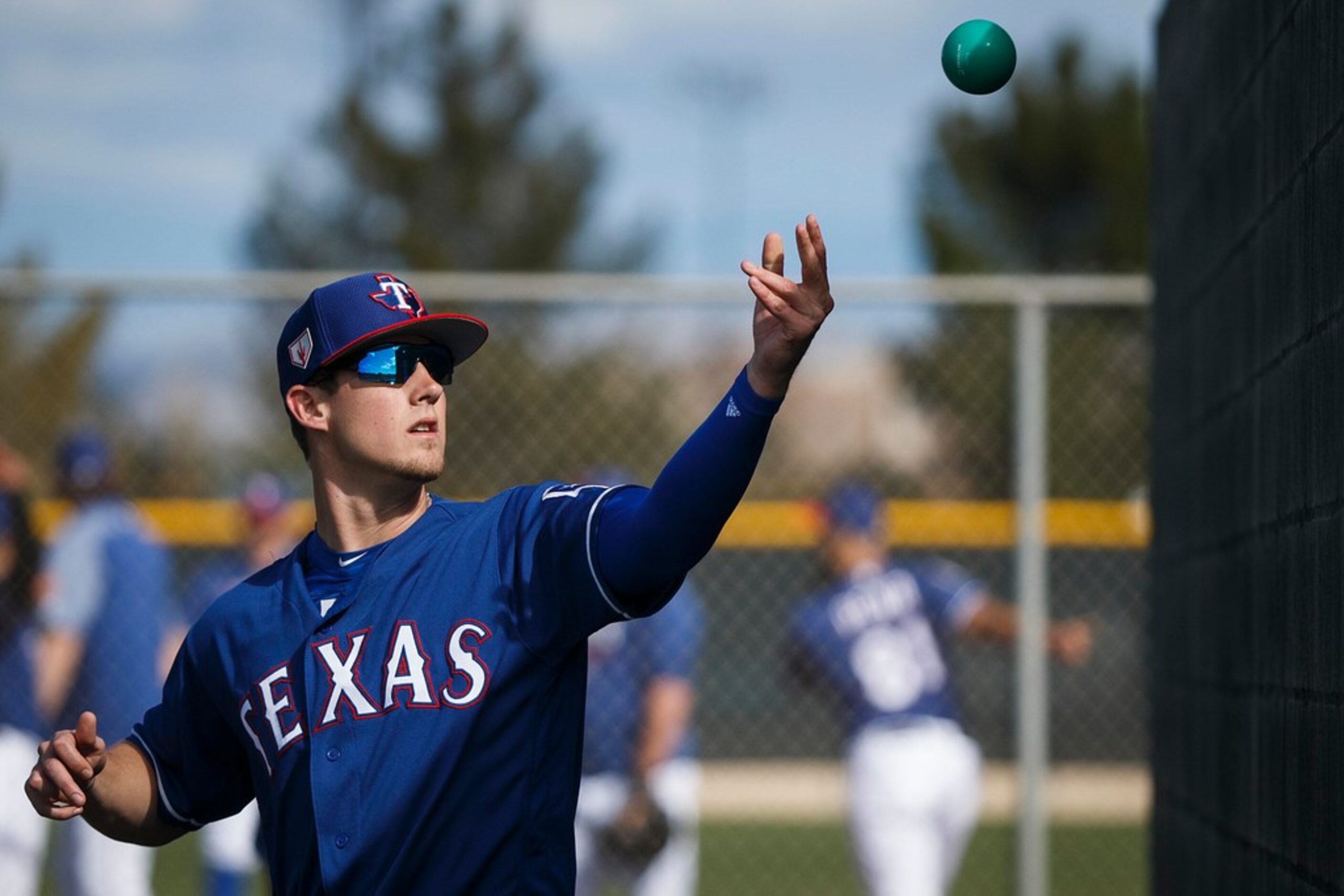 Texas Rangers pitcher Kyle Bird tosses a heavy ball against a bullpen wall during a spring...