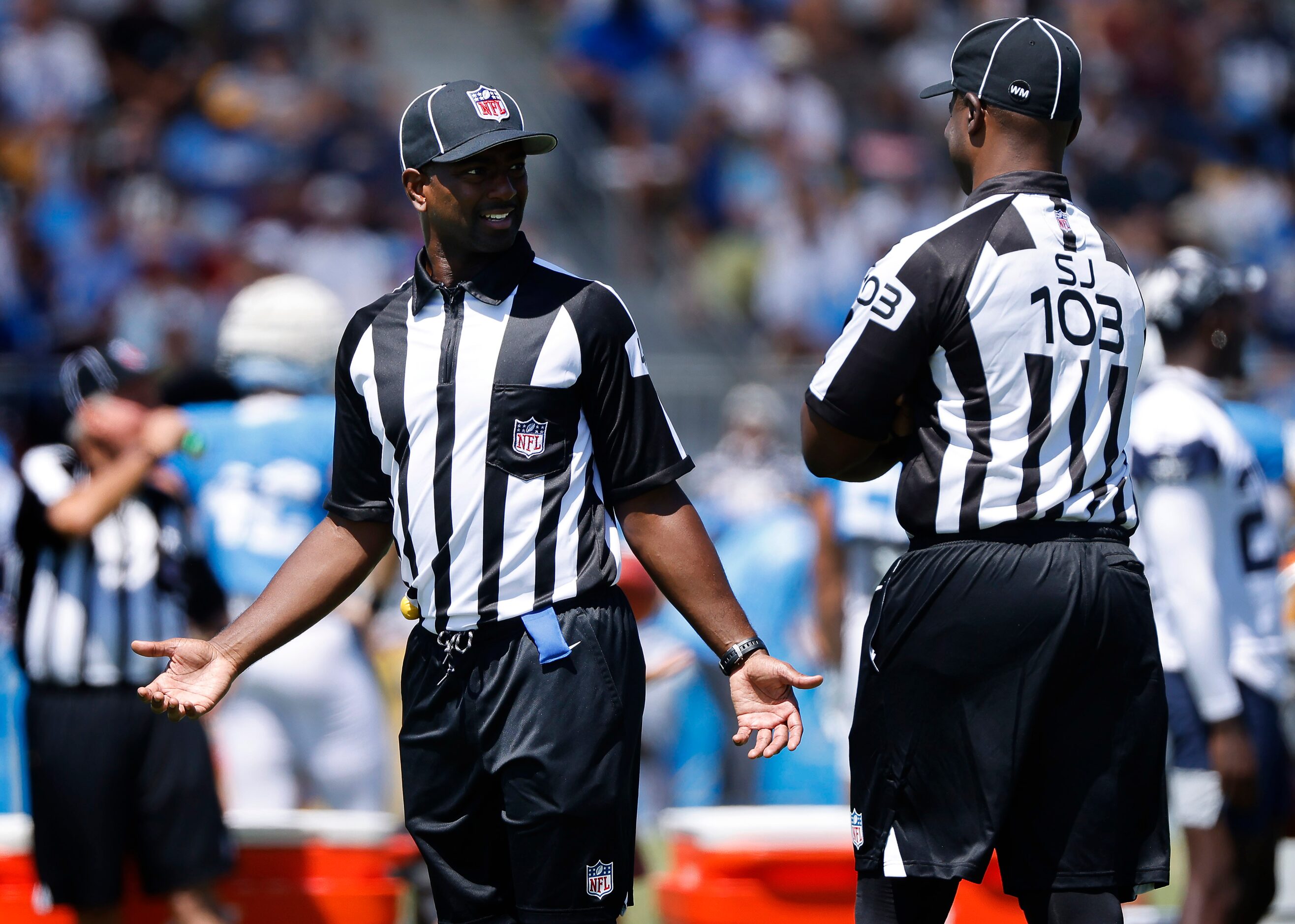 Field judge Nate Jones (42) visits with side judge Eugene Hall (103) during a joint practice...