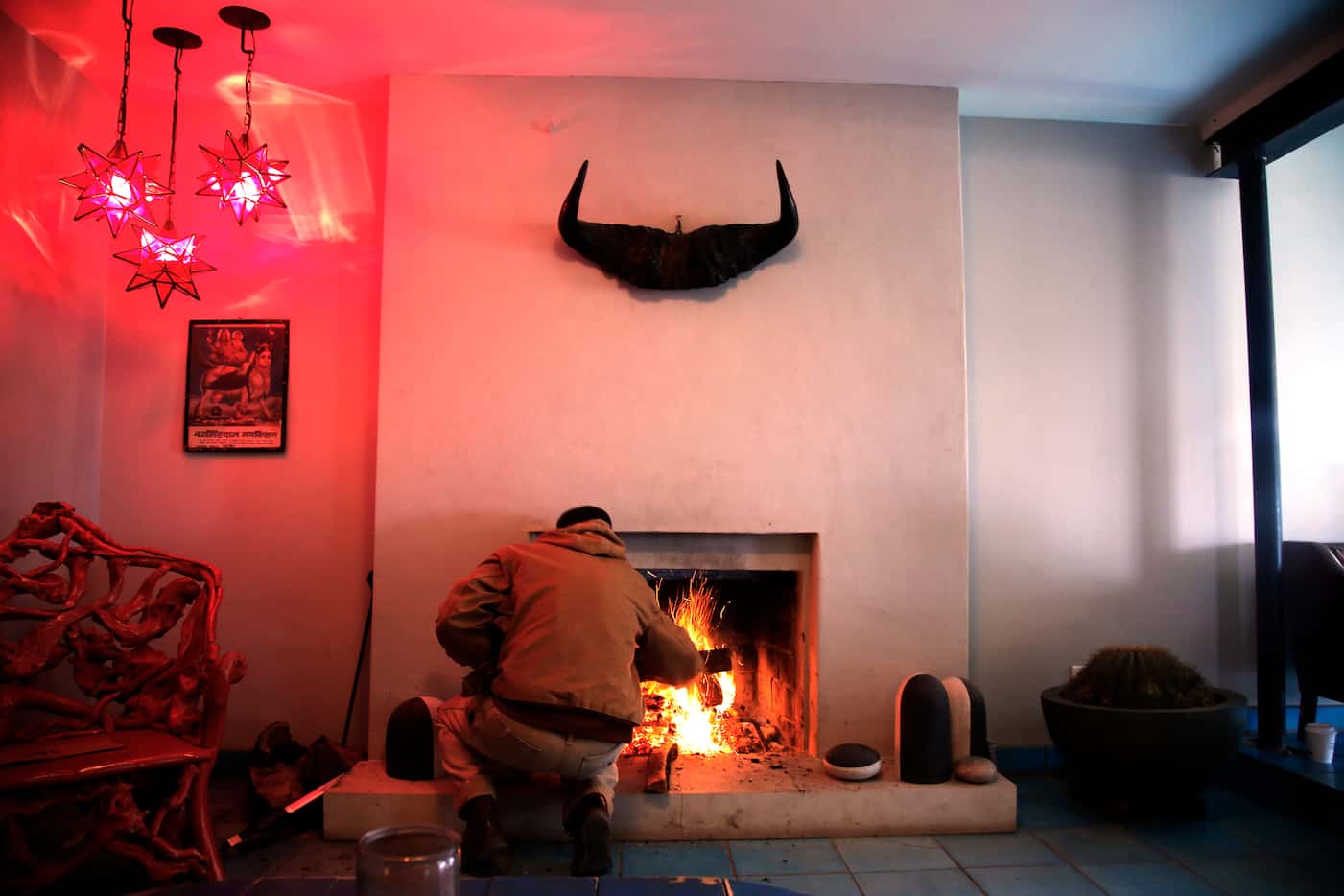 An employee adds logs to the fire in El Cosmico's lobby. (Guy Reynolds/Staff Photographer)