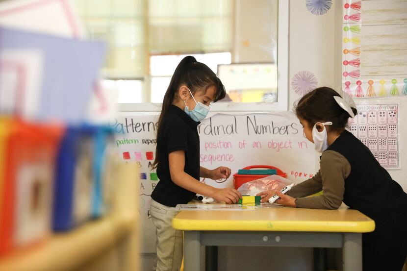 Preschoolers Elyianna Torres and Lucia Sanchez (right) work on individual activites during...