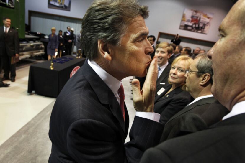 Gov. Rick Perry blew kisses to the crowd at a ceremonial bill signing for three bills...