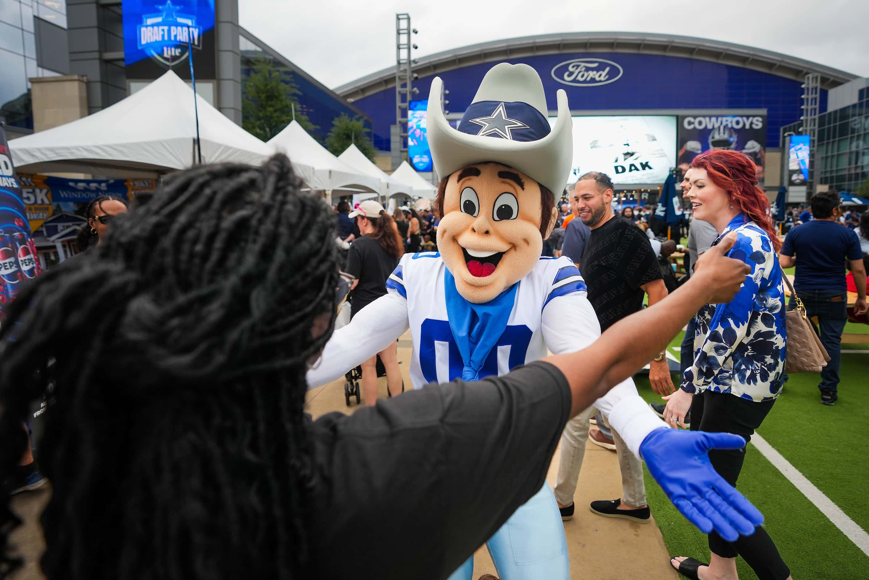 Dallas Cowboys mascot Rowdy hugs fans during a draft party before the first round of the NFL...