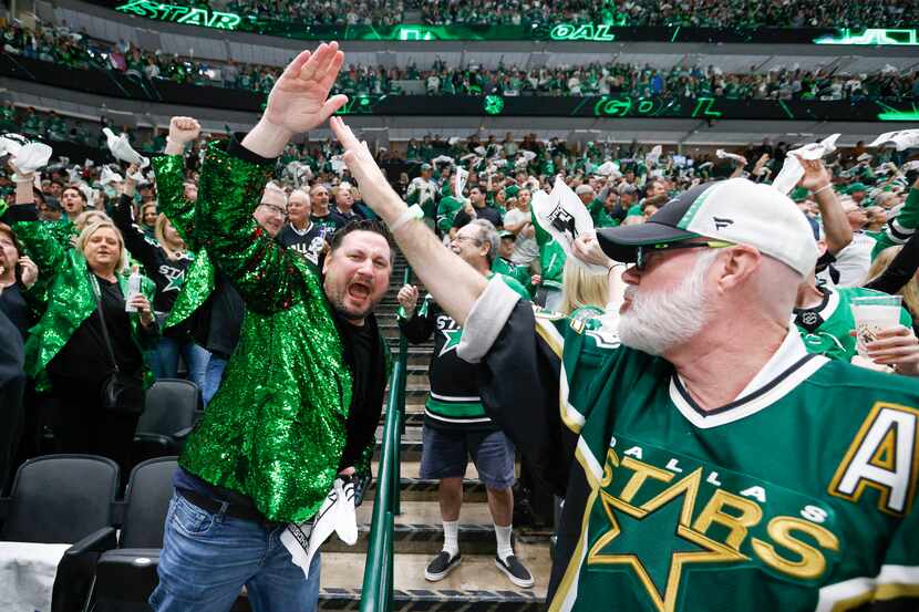 Dallas Stars fans Michael Gonterwitz (left) and Lou Helsen high-five after a goal by center...