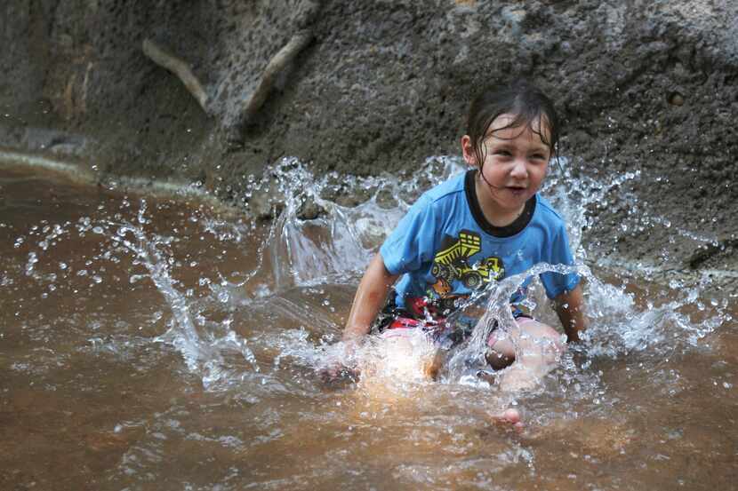 Conner Vasquez, 3, splashes in the Riverbank Monday June 11, 2012 at the San Antonio Zoo....