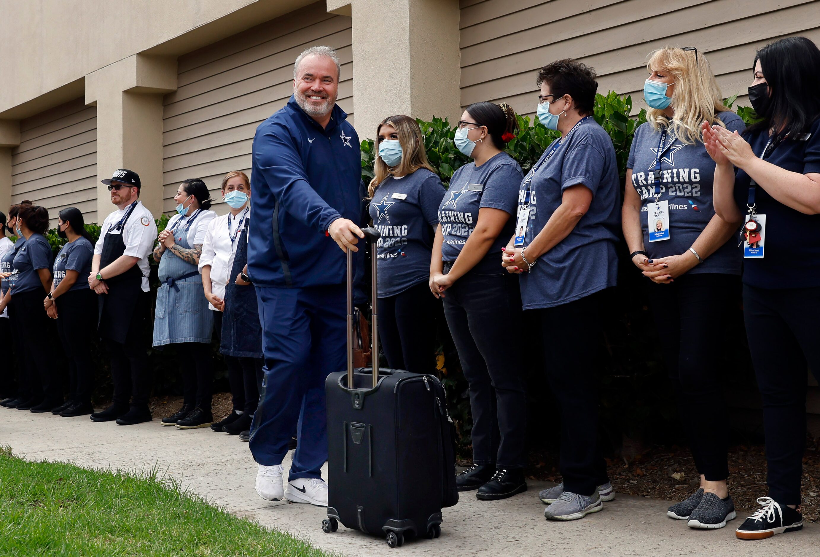 Employees line up to greet Dallas Cowboys head coach Mike McCarthy and the team as they...