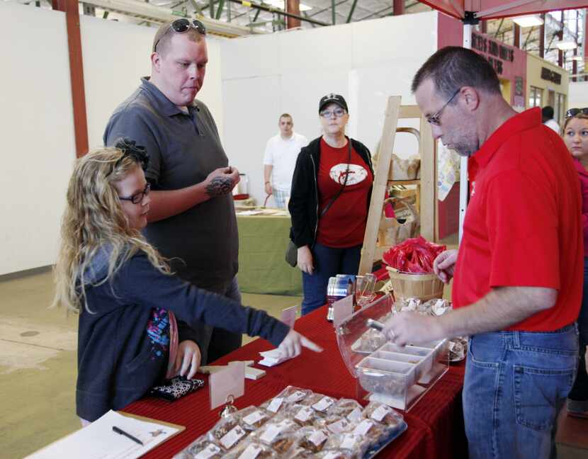 Mikayla Fox, 8, and her dad, Brian Fox, both of Kaufman, sample the toffee at the Texas...