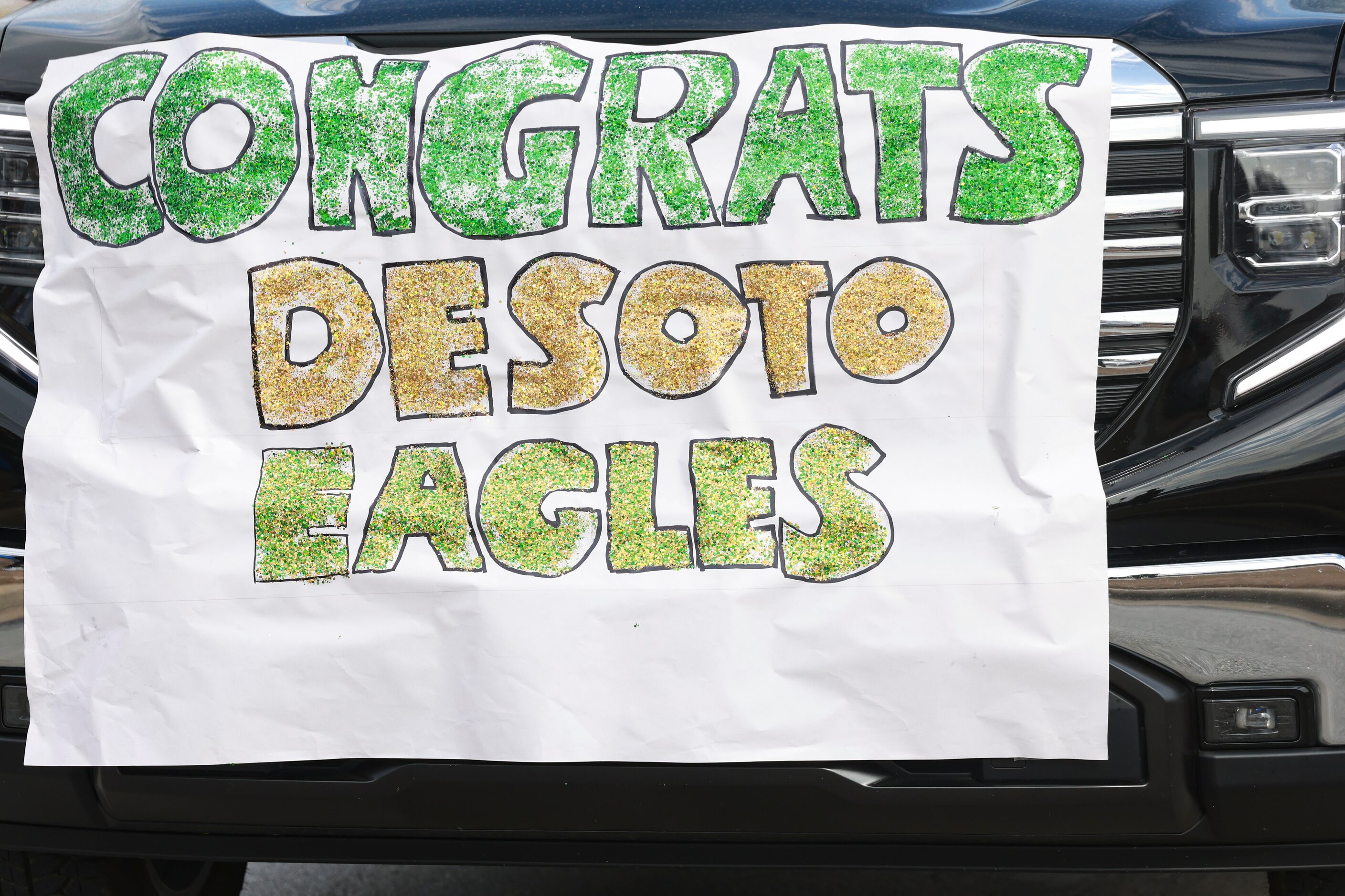 A truck with a sign on it celebrating DeSoto’s win rolls down the street in the parade,...