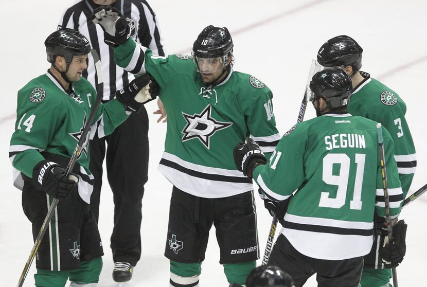 Dallas Stars left wing Jamie Benn (14) is congratulated by teammates Patrick Sharp (10),...