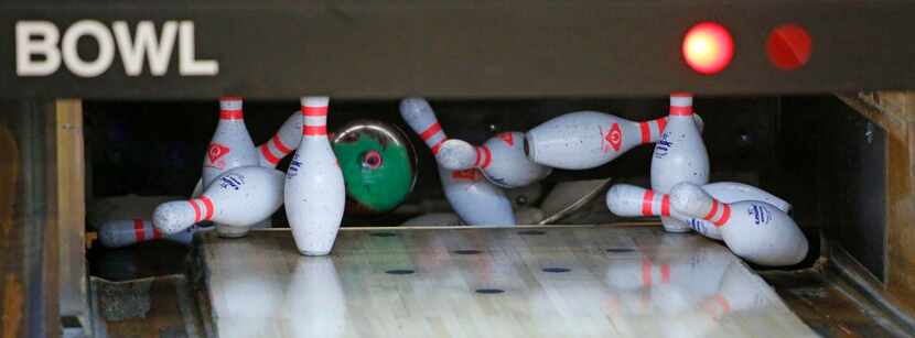 
A set of pins are knocked down during an Allen High School bowling team practice. 
