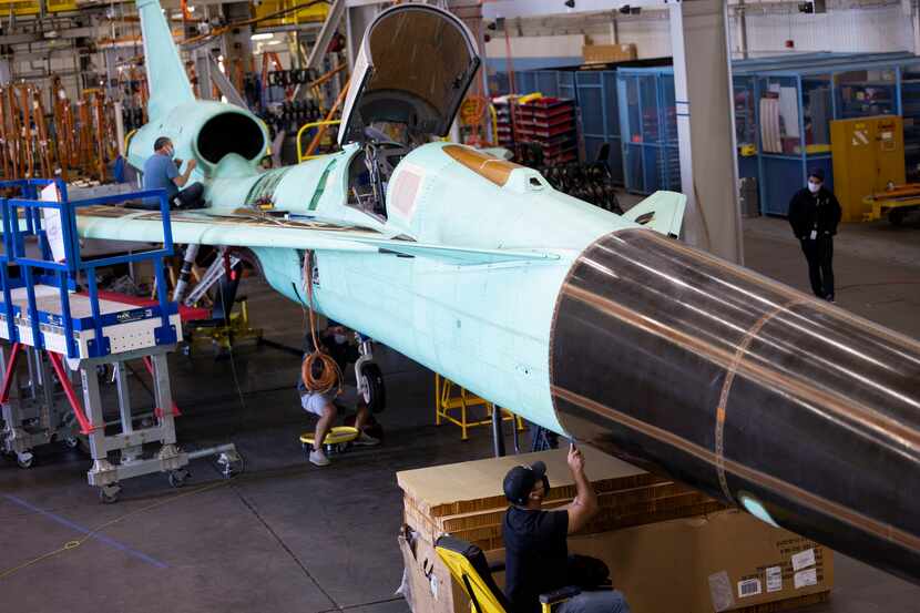 Technicians inspect the NASA X-59 QueSST (Quiet SuperSonic Technology) experimental aircraft...