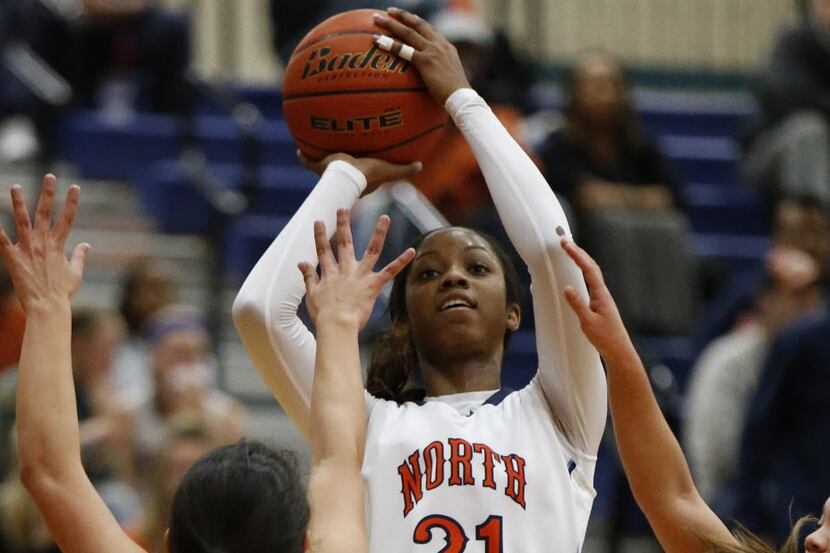 McKinney North's Chanterria Jackson (21) takes a shot for two points in front of McKinney's...