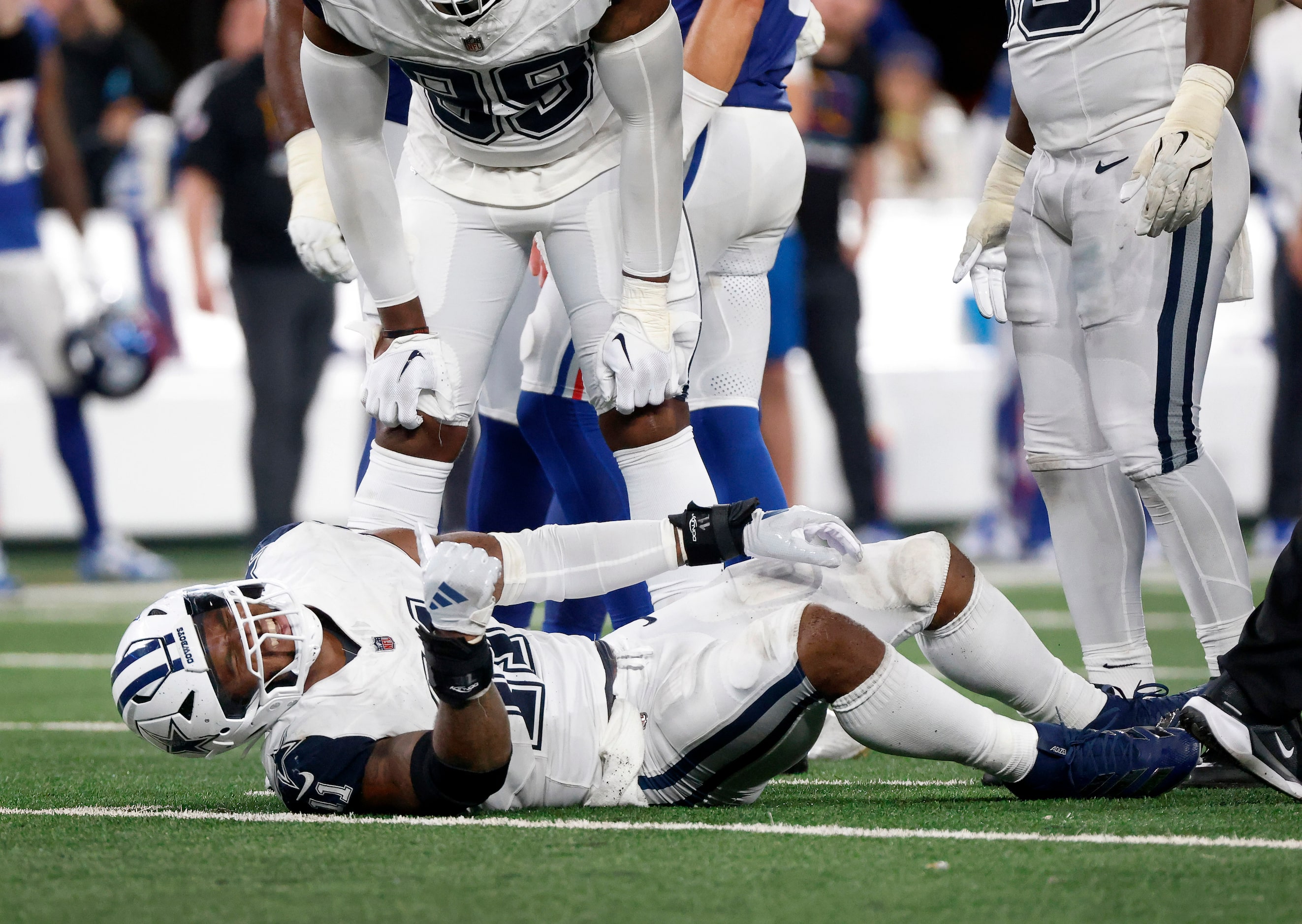 Dallas Cowboys linebacker Micah Parsons (11) writhes in pain after sustaining a fourth...