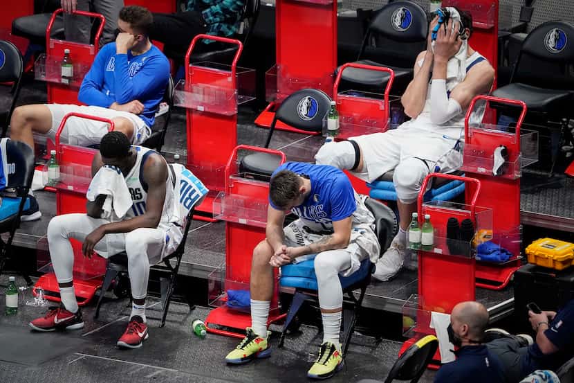 Dallas Mavericks guard Luka Doncic sits (bottom right) on the bench with forward Dorian...