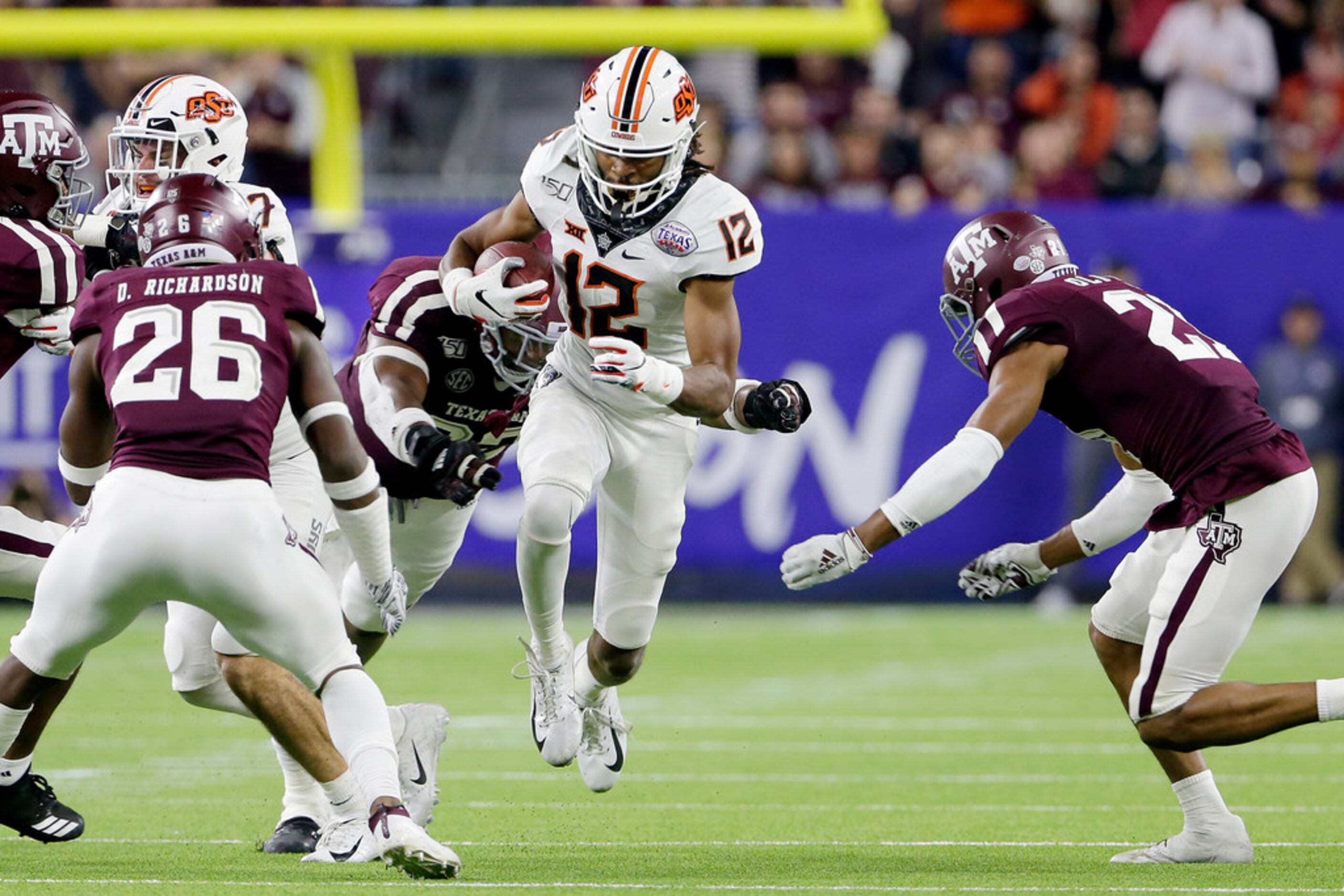 Oklahoma State wide receiver Jordan McCray (12) tries to make it through Texas A&M...