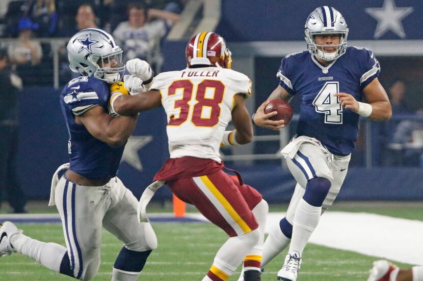 Dallas Cowboys quarterback Dak Prescott (4) scrambles for yardage as running back Ezekiel...