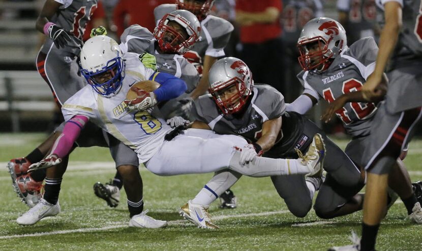 TXHSFB Conrad senior running back Duke Toweh (8) is tackled by the Woodrow Wilson defense...