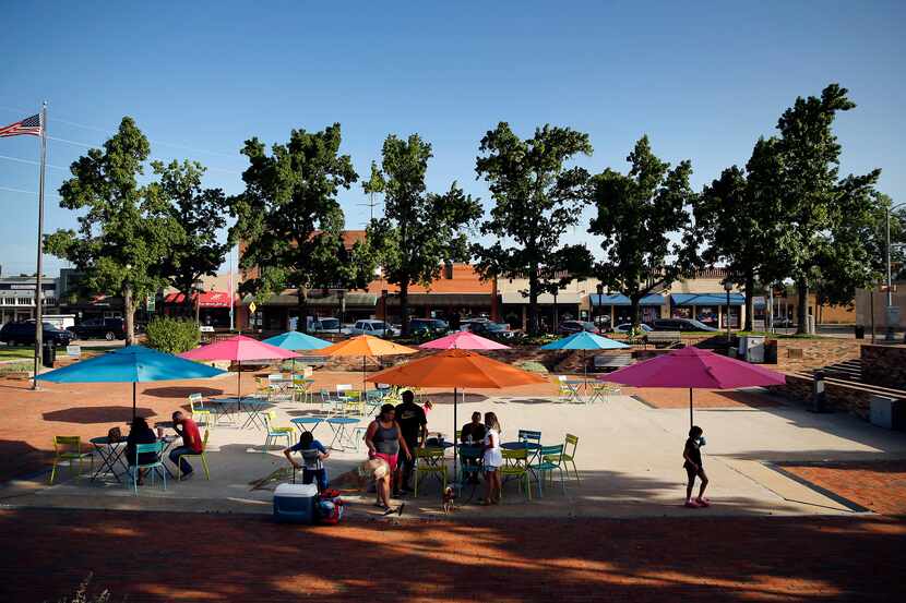 People find shade from the sun in Garland City Square in downtown Garland, Texas, Friday,...