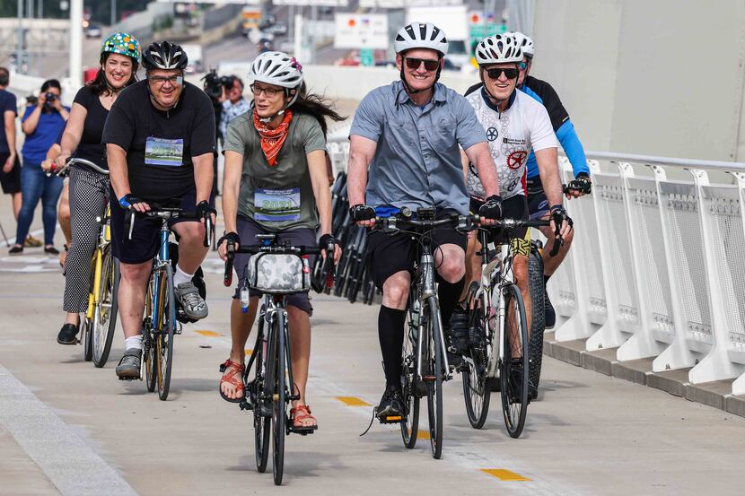 Dallas County Judge Clay Jenkins, along with a group of cyclists, ride their bikes during...